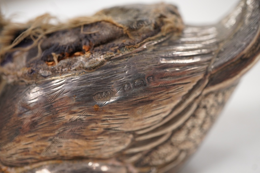 An Edwardian novelty silver mounted pin cushion, modelled as a duck, by Abrahall & Bint, engraved with 'feather' decoration and glass eyes, Birmingham, 1906, length 94mm, height 59mm(a.f.).